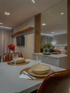 a kitchen with a table with plates and glasses on it at Infinity Tower Flat 1105 in Itapema