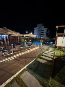 een zwembad met tafels en parasols bij Rooftop Carneirinho in Tamandaré