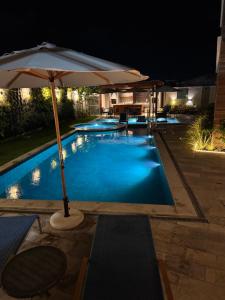 een zwembad met parasol bij Rooftop Carneirinho in Tamandaré