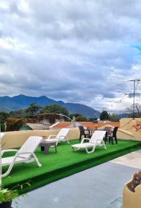een groep witte stoelen op een groen gazon bij Zoola Suites Antigua in Antigua Guatemala