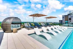 a pool on the roof of a building with chairs and umbrellas at The View - Navy Yard Washington DC in Washington, D.C.