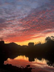 een zonsondergang boven een lichaam van water met een hemel bij Aurora Bliss - Fjordfront Jacuzzi & Sauna near Bergen in Askøy