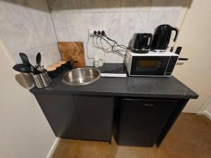 a kitchen counter with a sink and a microwave at A Sweet Studio for One in Altona +3 photos