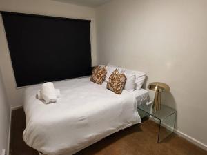 a white bed with pillows on it in a room at A Beachside Villa with Vogue Verve in Altona
