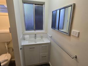 a bathroom with a sink and a window at A Beachside Villa with Vogue Verve in Altona