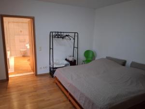 een slaapkamer met een bed en een kamer met een badkamer bij Apartment - östlicher Stadtteil in Kaiserslautern