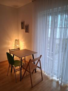 een tafel en stoelen in een kamer met een raam bij Apartment - östlicher Stadtteil in Kaiserslautern
