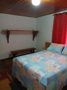 een slaapkamer met een bed met een kleurrijk dekbed bij Casa Amarela in Bocaina de Minas