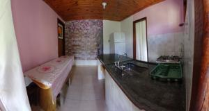 een badkamer met een wastafel en een bank. bij Casa Amarela in Bocaina de Minas