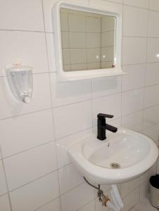 a white bathroom with a sink and a mirror at GuestHouse3 Karma369 in Plovdiv