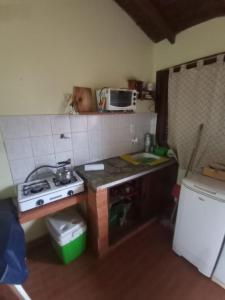 een kleine keuken met een fornuis en een spoelbak bij Mono Julian in Quequén