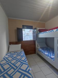 een slaapkamer met twee stapelbedden en een raam bij Jacuípe House in Camaçari