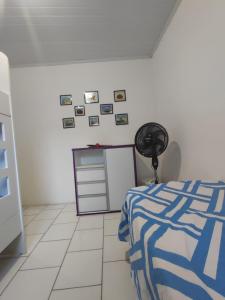 een slaapkamer met een bed en foto's aan de muur bij Jacuípe House in Camaçari