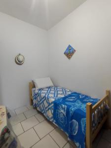 een slaapkamer met een bed met een blauw dekbed bij Jacuípe House in Camaçari