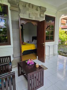 a room with a bed and a table and chairs at Berlian Inn Kuta Beach in Kuta +55 photos