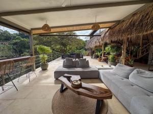 a patio with two couches and a table and chairs at Roca Verde Retreats & Car Rental in Atenas