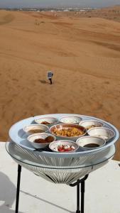 een dienblad met eten op een tafel naast een strand bij The mirage dome in Badīyah