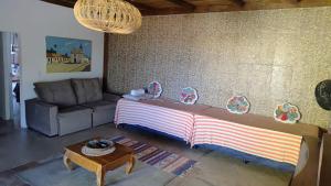a living room with a large bed and a couch at Paraiso Beach House in Santa Cruz Cabrália