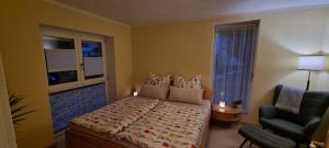 een slaapkamer met een bed, een stoel en een raam bij Ferienwohnung Bachklang Oberprechtal in Elzach