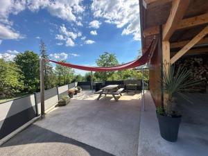 d'une terrasse avec un hamac sur le côté de la maison. dans l'établissement Country apartment, à Orgelet