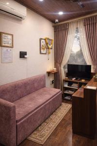 a living room with a couch and a tv at Hotel Tathastu Inn in Ujjain