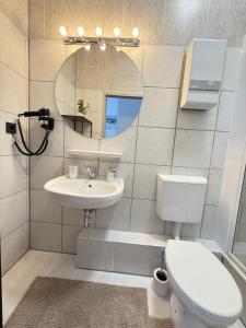 een badkamer met een toilet, een wastafel en een spiegel bij Time Wohnung in Wuppertal