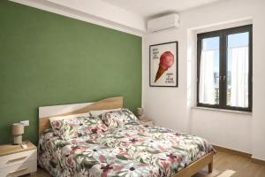 een groene slaapkamer met een bed en een raam bij La casa di Marzapane in Spigno Saturnia