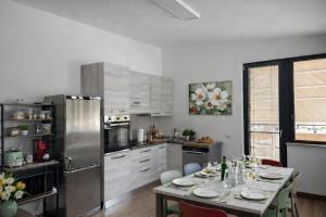a kitchen with a table and a refrigerator at La casa di Marzapane in Spigno Saturnia