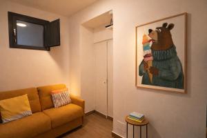a living room with a couch and a picture of a bear at La casa di Marzapane in Spigno Saturnia +1 photo