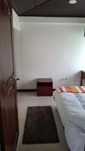 a bedroom with a bed and a small rug at Cabaña el Rincon Del Lago in Paipa