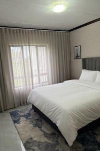 a bedroom with a large bed and a large window at The Gentle Nest in Trevallyn +22 photos