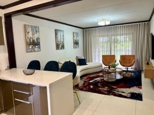 a living room with a couch and a table and chairs at The Gentle Nest in Trevallyn
