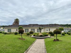 a house with a brick walkway in front of a yard at The Gentle Nest in Trevallyn