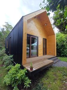 a tiny house with a large window and a deck at ECO CABAÑA in Puerto Varas