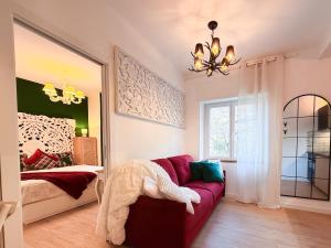 a living room with a red couch and a bed at FORTUNA ORO in montagna in Spormaggiore