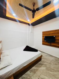 a bedroom with a ceiling fan and a bed at Hotel Tathastu Inn in Ujjain +17 photos