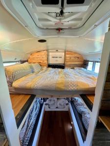 a bed in the back of a camper van at Camp Bonnie in Kent +6 photos