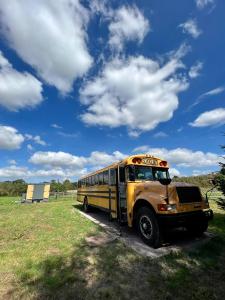 a yellow school bus parked in a field at Camp Bonnie in Kent