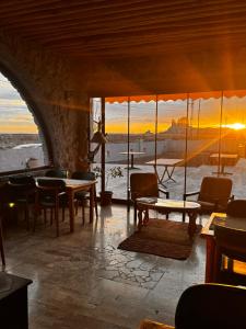 a room with tables and chairs and a view of the ocean at Soleado Cappadocia Hotel in Uçhisar