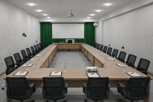Cette grande chambre dispose de tables, de chaises et d'un écran blanc. dans l'établissement Khatai Deluxe Hotel, à Baku 120 autres photos