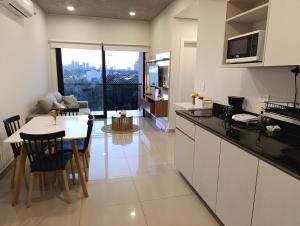 een keuken en woonkamer met een tafel en stoelen bij Departamento con excelente ubicación in Luque