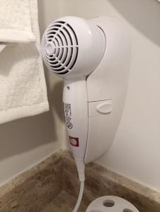 een witte haardroger op de vloer in een badkamer bij Departamento con excelente ubicación in Luque