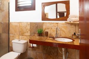 a bathroom with a toilet and a sink and a mirror at Kitenest in Itarema +30 photos