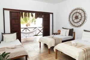 a room with two beds and a view of a patio at Kitenest in Itarema