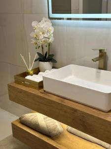 a bathroom with a white sink on a wooden counter at Apartman Centar - Posušje in Posušje +20 photos