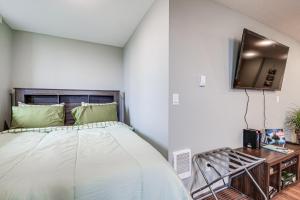 ein Schlafzimmer mit einem Bett und einem Fernseher an der Wand in der Unterkunft 4 Blocks to Riverwalk Updated Astoria Studio in Tongue Point Village