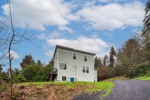 Ein weißes Haus auf einem Hügel mit einer Straße in der Unterkunft 4 Blocks to Riverwalk Updated Astoria Studio in Tongue Point Village