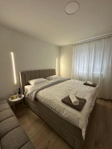 a bedroom with a large bed and a couch at Apartman Centar - Posušje in Posušje