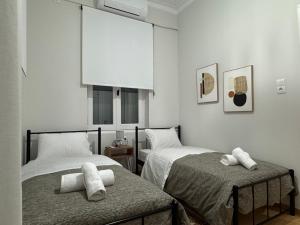 a bedroom with two beds and a white wall at Sea & Stone House in Nafpaktos