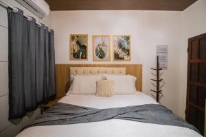 a bedroom with a bed with four pictures on the wall at Pousada da Leide in Fernando de Noronha +186 photos